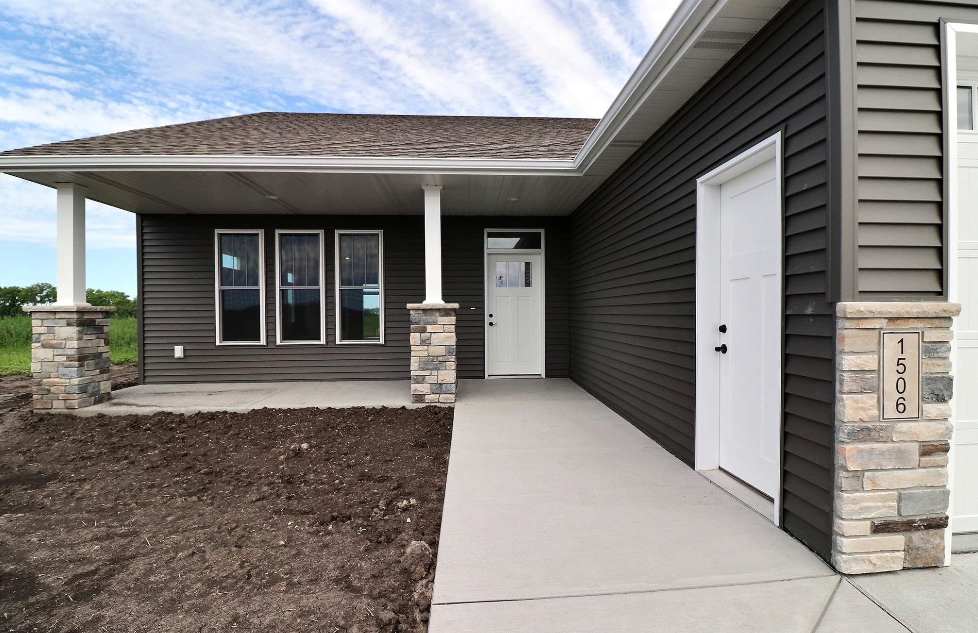 Covered front porch with stone columns on a Rick Halvorson Construction custom home